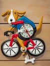Cute clock on the wall in shape of dog cycling on bicycle. Children toy clock fugurine. Allen designs bicycle dog clock
