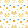 Cute colorful Hanukkah vector seamless pattern background with dreidels, coins, sufganiyot and menorah with nine lighting candles