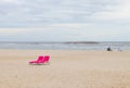 Cute and colorful pink beach chairs on the beach.