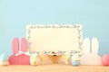 Cute colorful wooden bunny ears and easter eggs over wooden table. Royalty Free Stock Photo