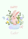 Cute composition with a rabbit sitting in a basket, spring flowers, butterflies and Easter eggs. Spring flowering