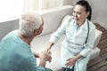 Cute concentrated nurse sitting and calming her patient.