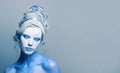 Cute cool cold woman with blue and white body art, carnival makeup and hairstyle portrait