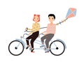 Cute couple dressed in trendy clothes riding tandem bicycle and holding kite. Young man and woman sitting on bike Royalty Free Stock Photo