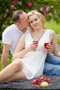 Cute couple drinking red wine on a picnic smiling at each other on a sunny day Royalty Free Stock Photo
