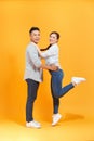 Cute couple, guy holding carrying lady lovely moment isolated yellow color background