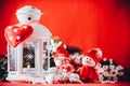 Cute couple of little snowmen is standing near the white fairy lantern with a toy heart on it and decorated fir tree branch. Royalty Free Stock Photo