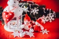 Cute couple of little snowmen is standing near the white fairy lantern with a toy heart on it and decorated fir tree branch. Royalty Free Stock Photo