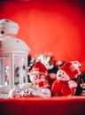 Cute couple of little snowmen is standing near the white fairy lantern with a toy heart on it and decorated fir tree branch. Royalty Free Stock Photo