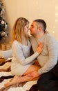 Cute couple in love enjoying moments next to a Christmas tree