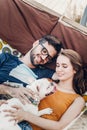 Cute couple lying in a hammock with a dog, funny white bulldog relaxing with a hipster young family on a beach, family portrait Royalty Free Stock Photo