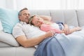 Cute couple napping under a blanket on the couch Royalty Free Stock Photo