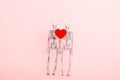 Couple of skeletons with red heart on a pink background