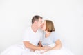 Cute couple in sleepwear on the bed. Husband holding hand on stomach of his pregnant wife. Happy and loving family morning concept Royalty Free Stock Photo