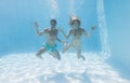 Cute couple smiling at camera underwater in the swimming pool