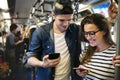 Cute couple using smartphones on the subway