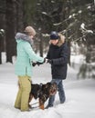 Cute couple walking and having fun with their dog in winter forest Royalty Free Stock Photo