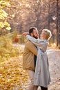 cute couple is walking in park at autumn leaf fall, resting in nature together. leisure. Royalty Free Stock Photo