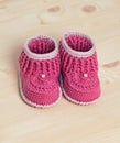 Cute Crochet baby booties on wooden background Royalty Free Stock Photo