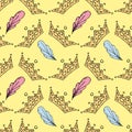 Cute crowns and pink and blue feathers on yellow background, vector seamless pattern