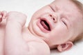 Cute crying baby on a light background Close up.