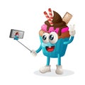 Cute cupcake mascot takes a selfie with smartphone