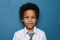 Cute curious African American child schoolboy student 6 years old on blue backgroung. Black kid boy portrait Royalty Free Stock Photo