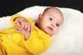 Portrait of curious baby boy lying on back on white fur Royalty Free Stock Photo