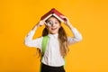 Cute Curious Schoolgirl Looking Through Magnifier Covering Head With Book