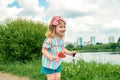 Cute curly baby girl eating watermelon candy in a sunny park. baby with outdoors lollipop Royalty Free Stock Photo