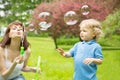 Cute curly baby with soap bubbles. children playing