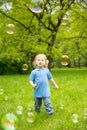 Cute curly baby with soap bubbles. children playing