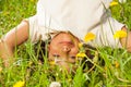 Cute curly boy stands upside down in field