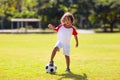 Cute curly little boy playing football. Kids play Royalty Free Stock Photo