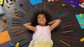 Cute curly preschool African American girl on floor thinking about holidays