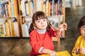 Cute dark-eyed girl with Down syndrome taking her glasses off