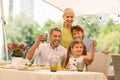 Cute dark-haired girl making selfie with brother and grandparents