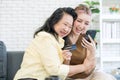 Cute daughter and elderly mom hugged each other using smartphone online shopping use credit card online at living room Royalty Free Stock Photo