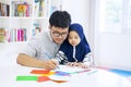 Cute daughter learning how to draw with her father
