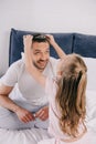 Daughter putting diadem on smiling daddy on fathers day