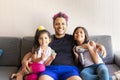 Cute daughters are painting the nails and combing the hair of their handsome young father Royalty Free Stock Photo