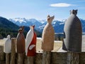 Cute decorative ceramic animals on wooden fence, Austrian Alps in the background. Royalty Free Stock Photo