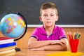 Cute diligent boy sitting in classroom