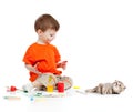 Cute dirty child with paints looking at cat