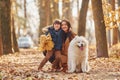 WIth cute dog. Mother with her son is having fun outdoors in the autumn forest Royalty Free Stock Photo