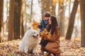 WIth cute dog. Mother with her son is having fun outdoors in the autumn forest Royalty Free Stock Photo