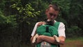 Cute dog pug sitting in the ergo device babycarrier or sling kangaroo carrier