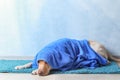 Cute dog with towel after washing lying on floor Royalty Free Stock Photo