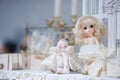 Cute doll on display. Kawaii innocent girl with blond hair in a white lace dress