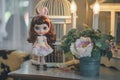 Cute doll. A cute doll stands among the vintage props setting including candles and cage. retro and dim light